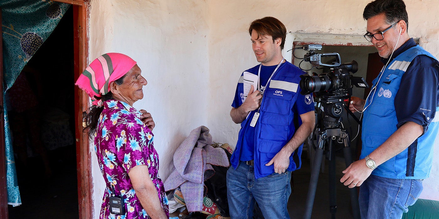 PAHO staff visit a community in a remote area of the Americas. They speak to an elderly woman.