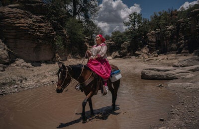 Julia montando a caballo para llegar a comunidad indígena y vacunar