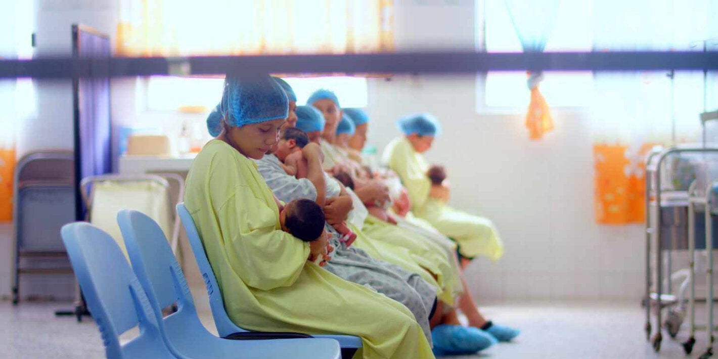 Várias mães amamentando recém-nascidos em um ambiente hospitalar